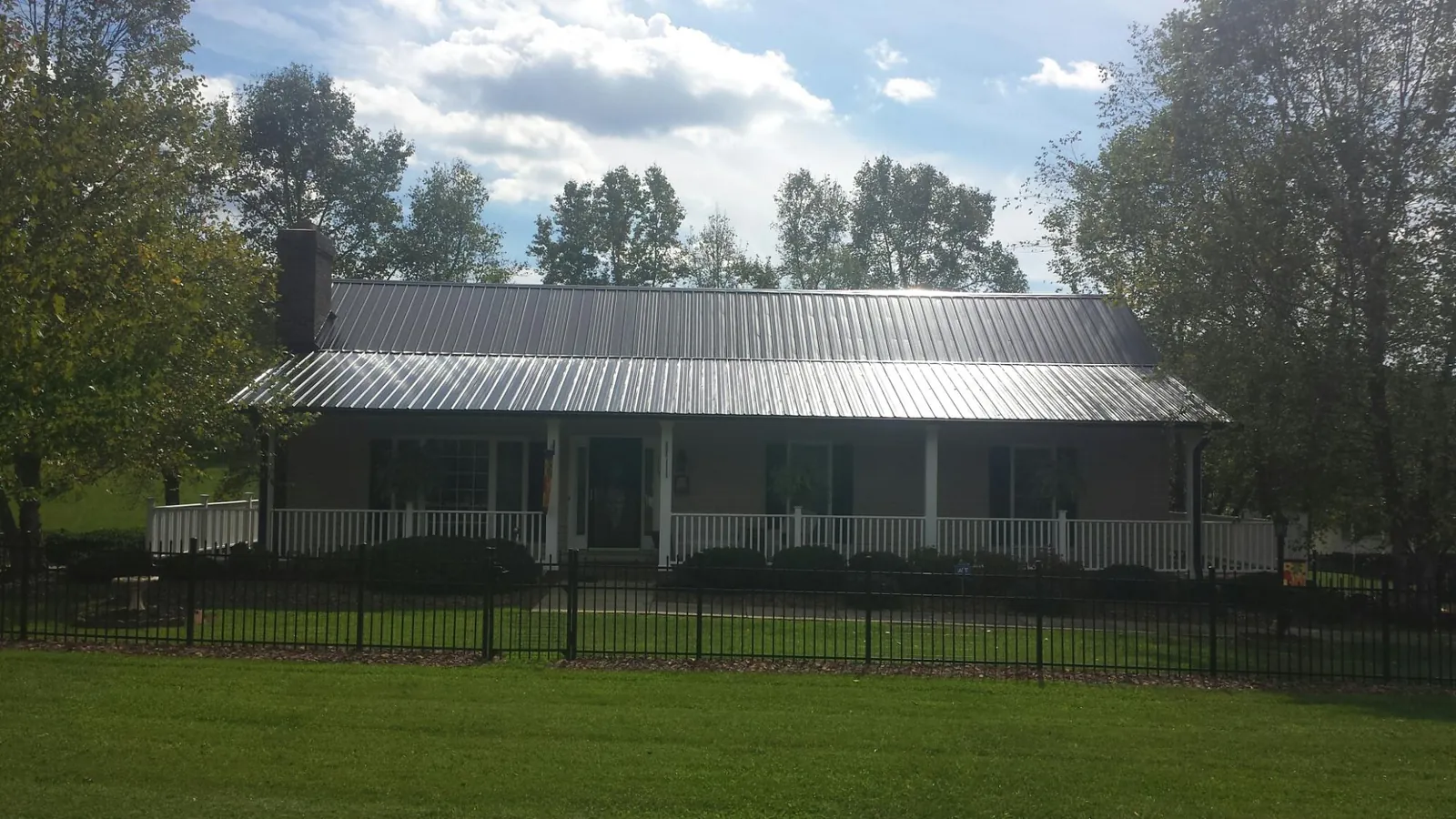 Gray metal roof on a brick ranch with a full width front porch — Gutter Guard Installation work by our crew in River Forest